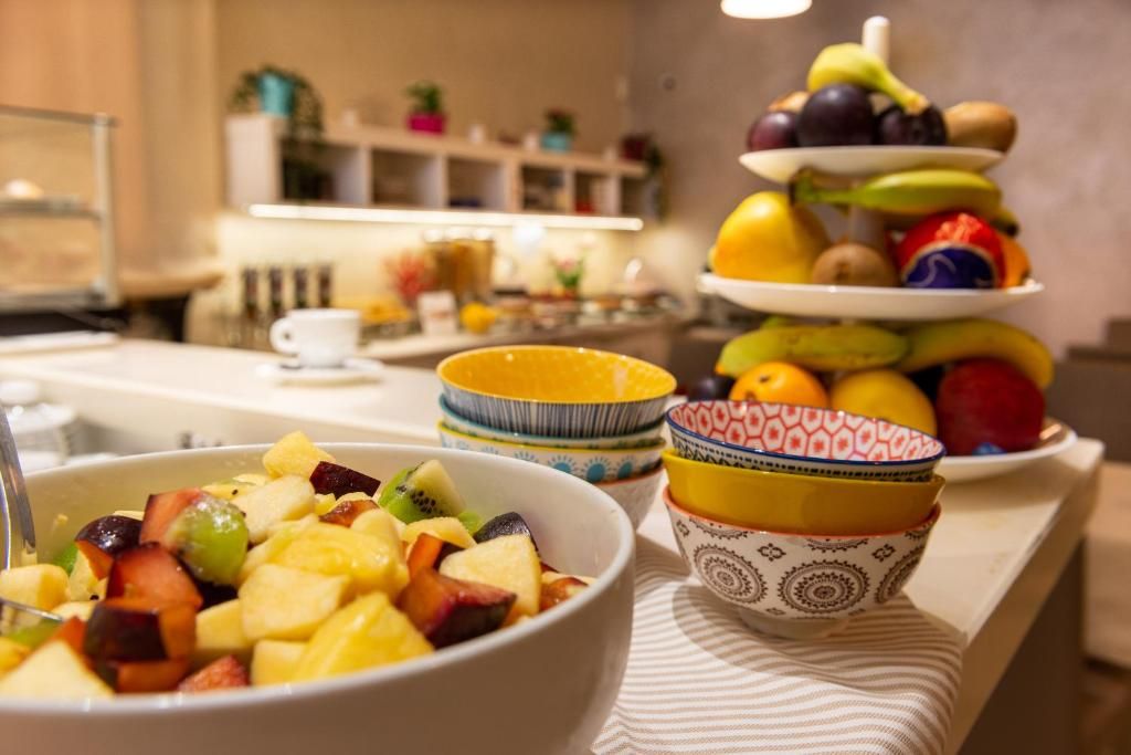 A breakfast setting with a fruit bowl, a fruit stack, and a coffee cup.