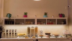 A buffet setup with various food items and condiments. - Hotel Mirandola (Mirandola)