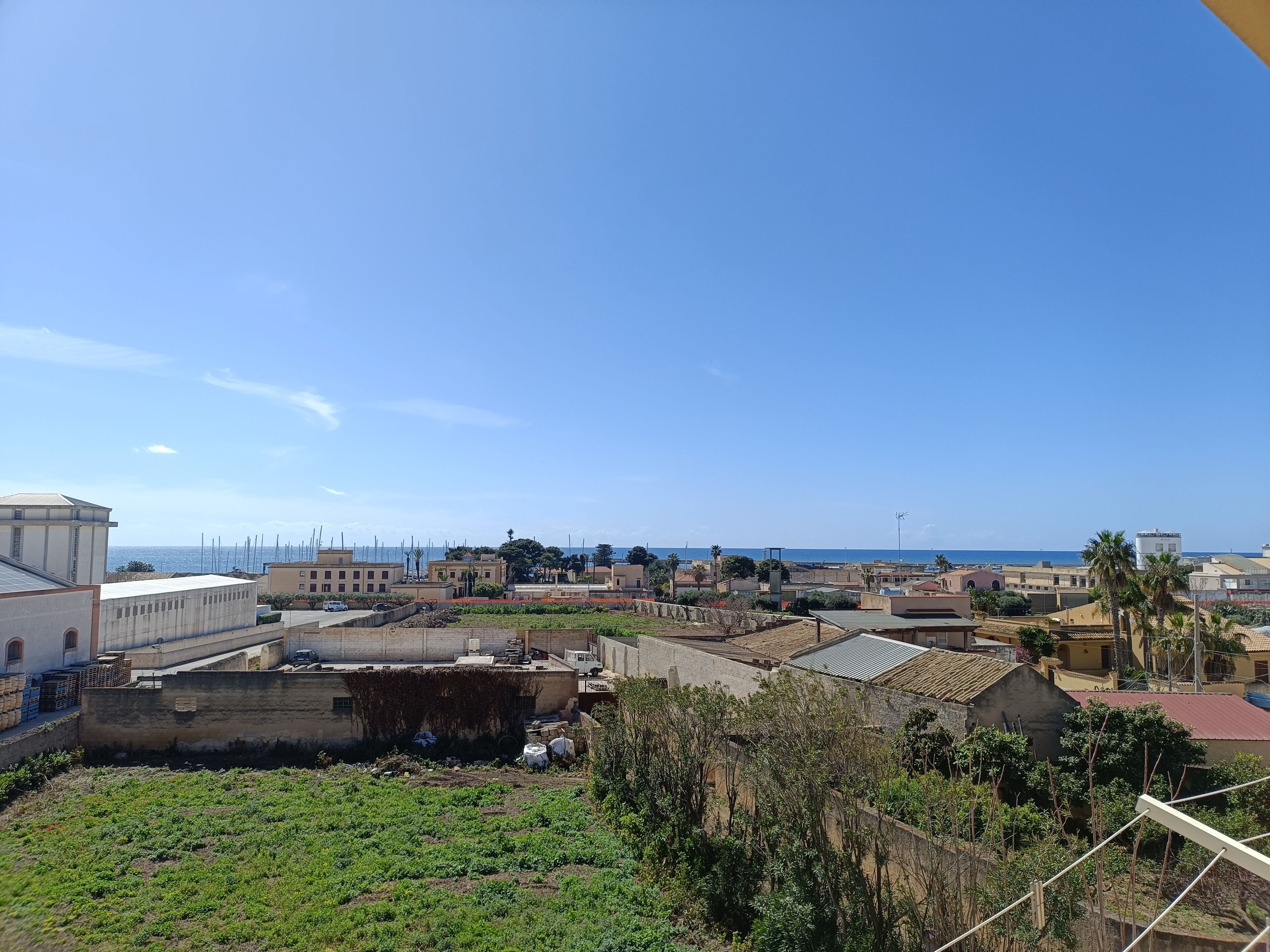 Eine Küstenstadt mit Gebäuden, klarem Himmel und Blick auf das Meer.