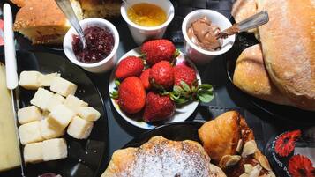 Una varietà di pasticcini, tra cui croissant e un dolce con fragole e zucchero a velo.
