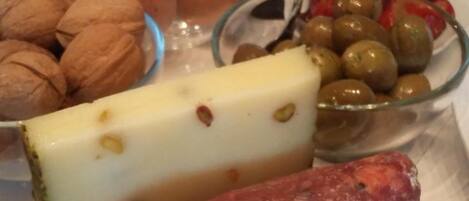A table with a variety of food items including cheese, olives, eggs, and nuts.