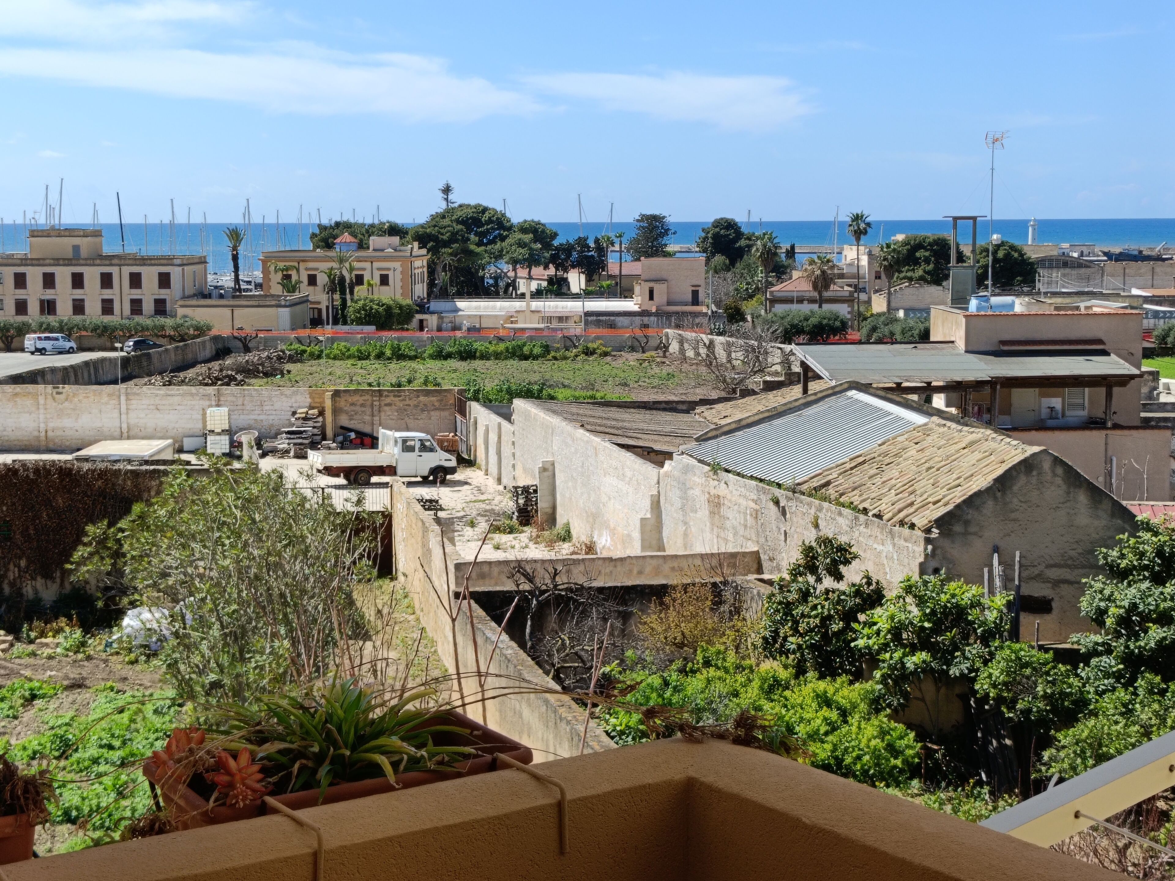 Un quartiere residenziale con edifici, una strada e vista sul mare.