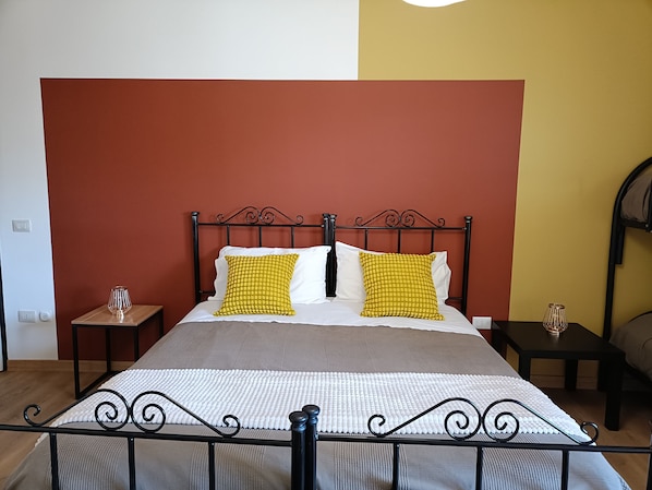 A bed with a metal frame, two pillows, a bedside table, and a wall with a two-tone color scheme.