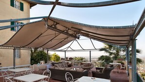 An outdoor patio with tables and chairs, a sofa, and a large canopy. - Villa Camaiore (Camaiore)