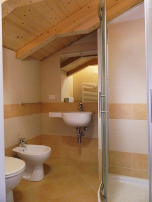 A bathroom with a toilet, bidet, sink, and shower. - Piccolo Hotel Tanamalia (Lizzano in Belvedere)
