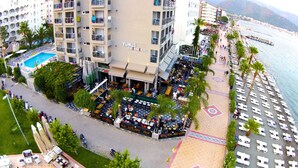 A hotel with outdoor seating, a pool, and a beach view. - Yunus Beach Hotel (Marmaris)