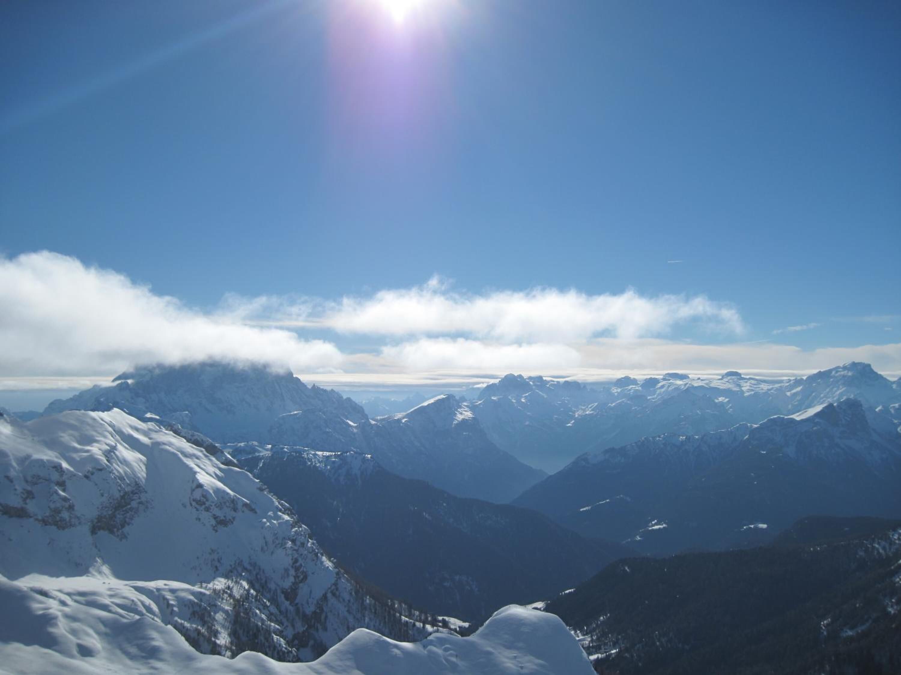 A mountain landscape with snow-covered peaks and a clear sky.