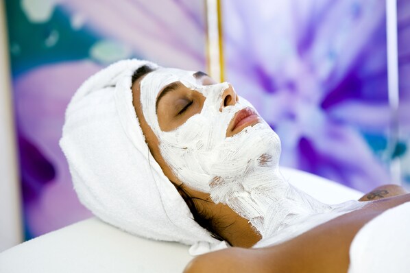 Una persona recostada con una toalla en la cabeza, evocando un ambiente de spa o relajación.