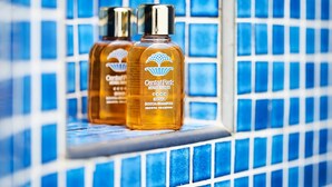 Two bottles of Central Park Hotel toiletries on a tiled ledge. - Central Park Hotel Terme (Ischia)