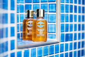 Two bottles of Central Park Hotel toiletries on a tiled ledge. - Central Park Hotel Terme (Ischia)