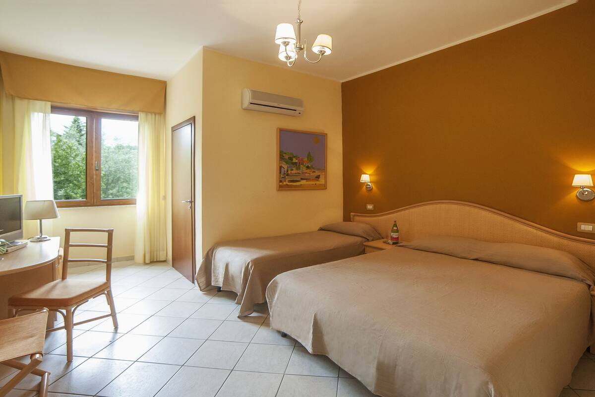 Classic Triple Room | Minibar, in-room safe, desk, bed sheets