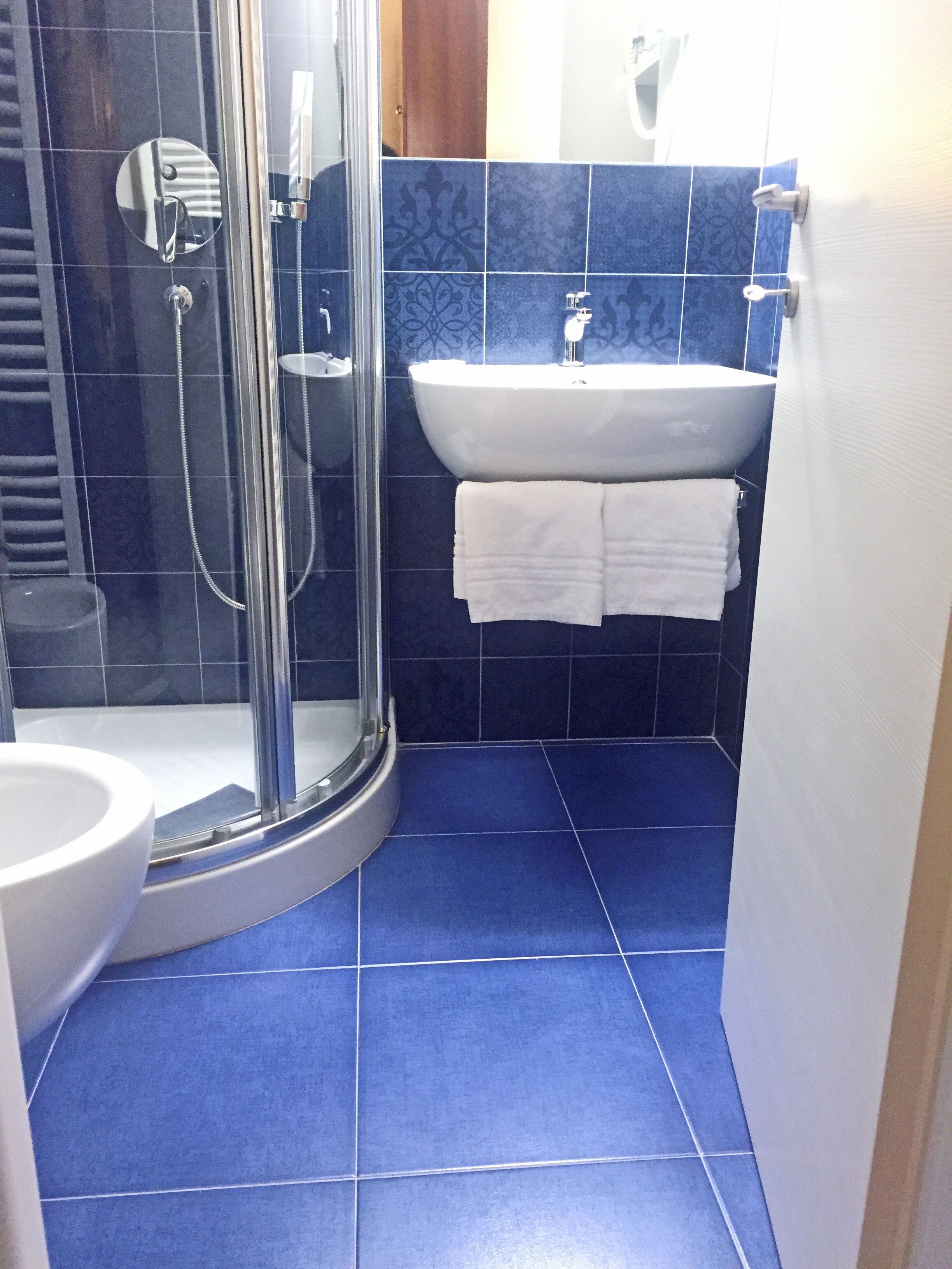 Une salle de bain avec une douche à parois de verre, un lavabo blanc et des toilettes.