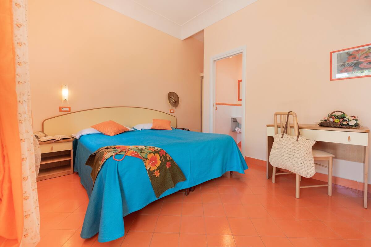 Ein Schlafzimmer mit einem Bett, einem Schreibtisch und einem Stuhl.