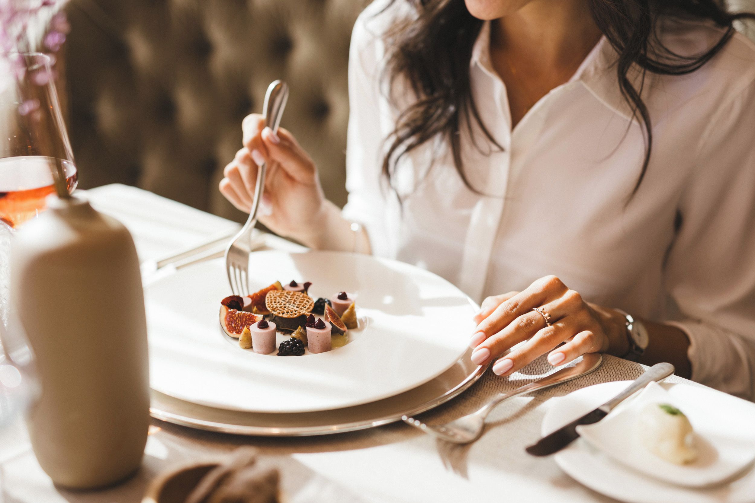 Una mesa con un plato de comida, un vaso de bebida y cubiertos.