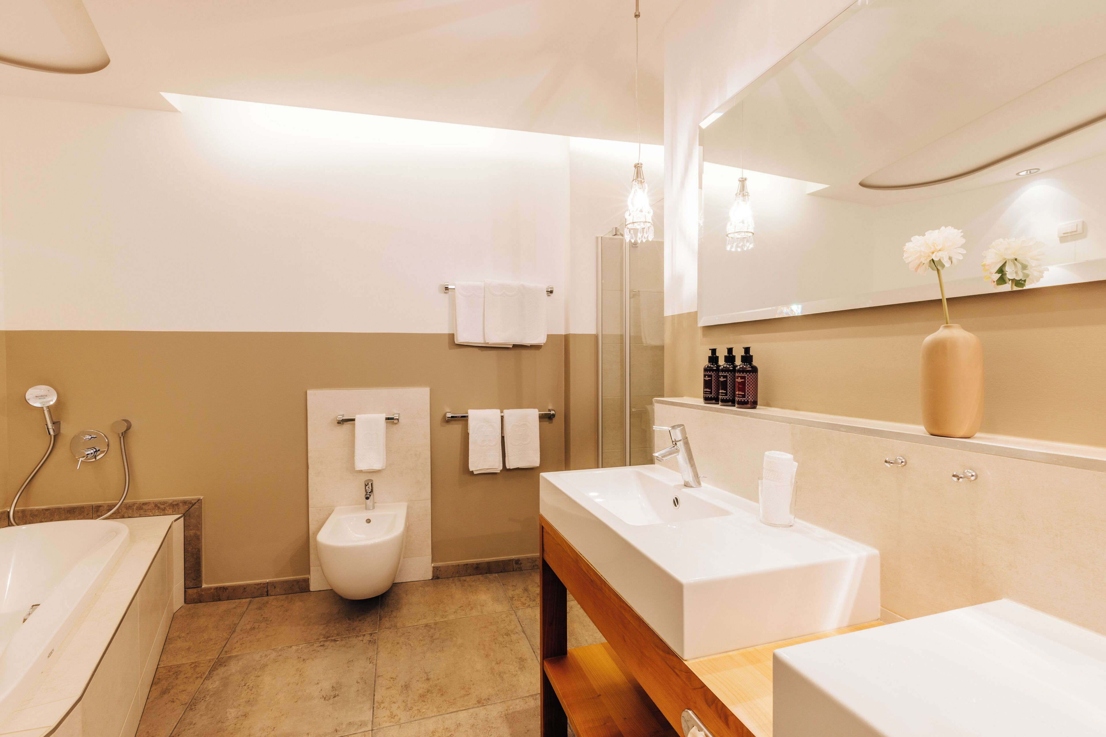 Un baño moderno con bañera, bidé y tocador con espejo.