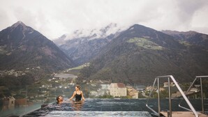 A pool with a view of mountains and a town. - Hotel Hohenwart (Schenna)