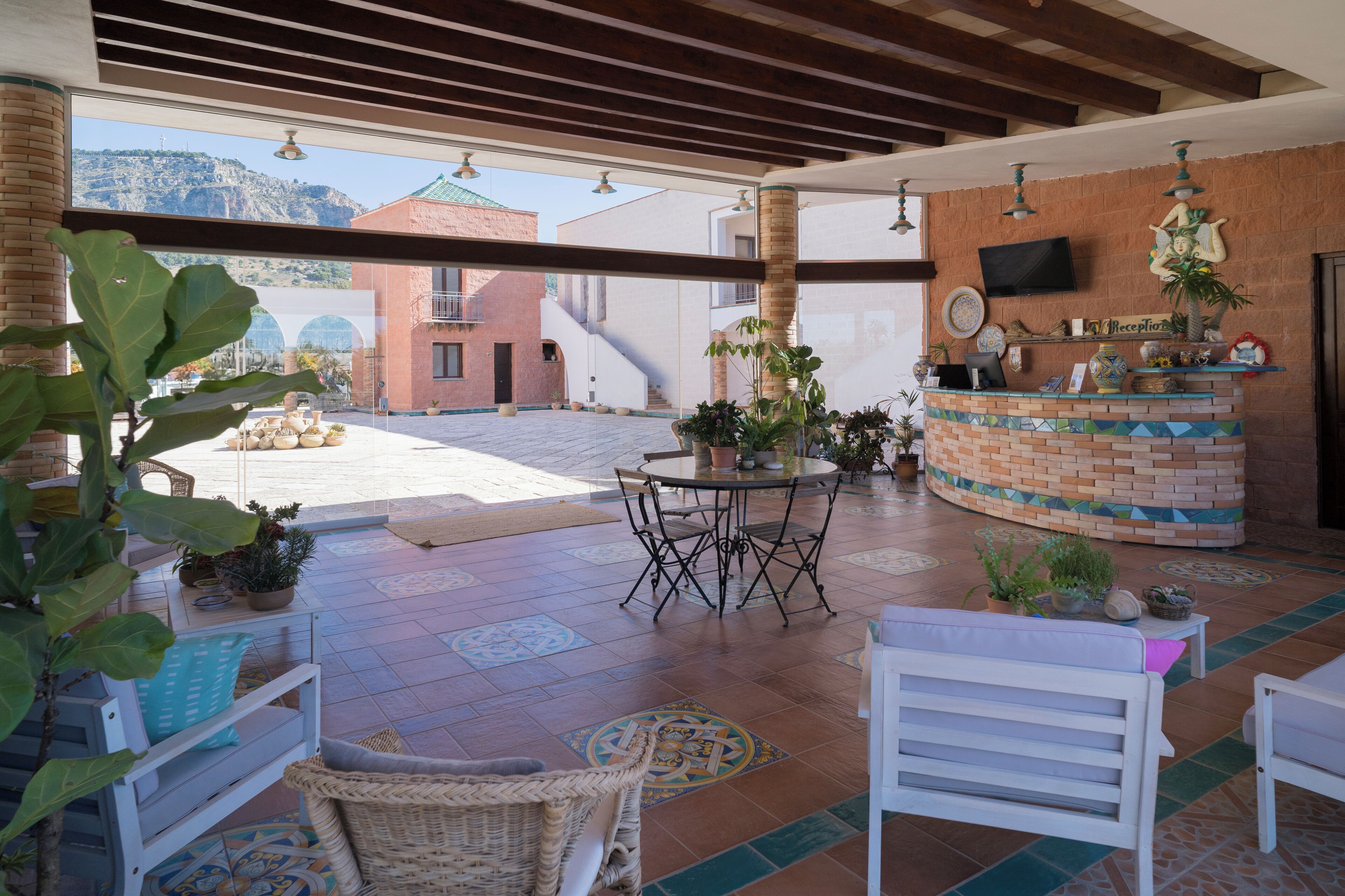 Un patio amplio con una recepción, zona de estar y vistas a las montañas.