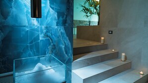 A modern bathroom with a blue marble wall, a glass water feature, and a staircase with candles. - Il Marchese Hotel & Spa (Sciacca)