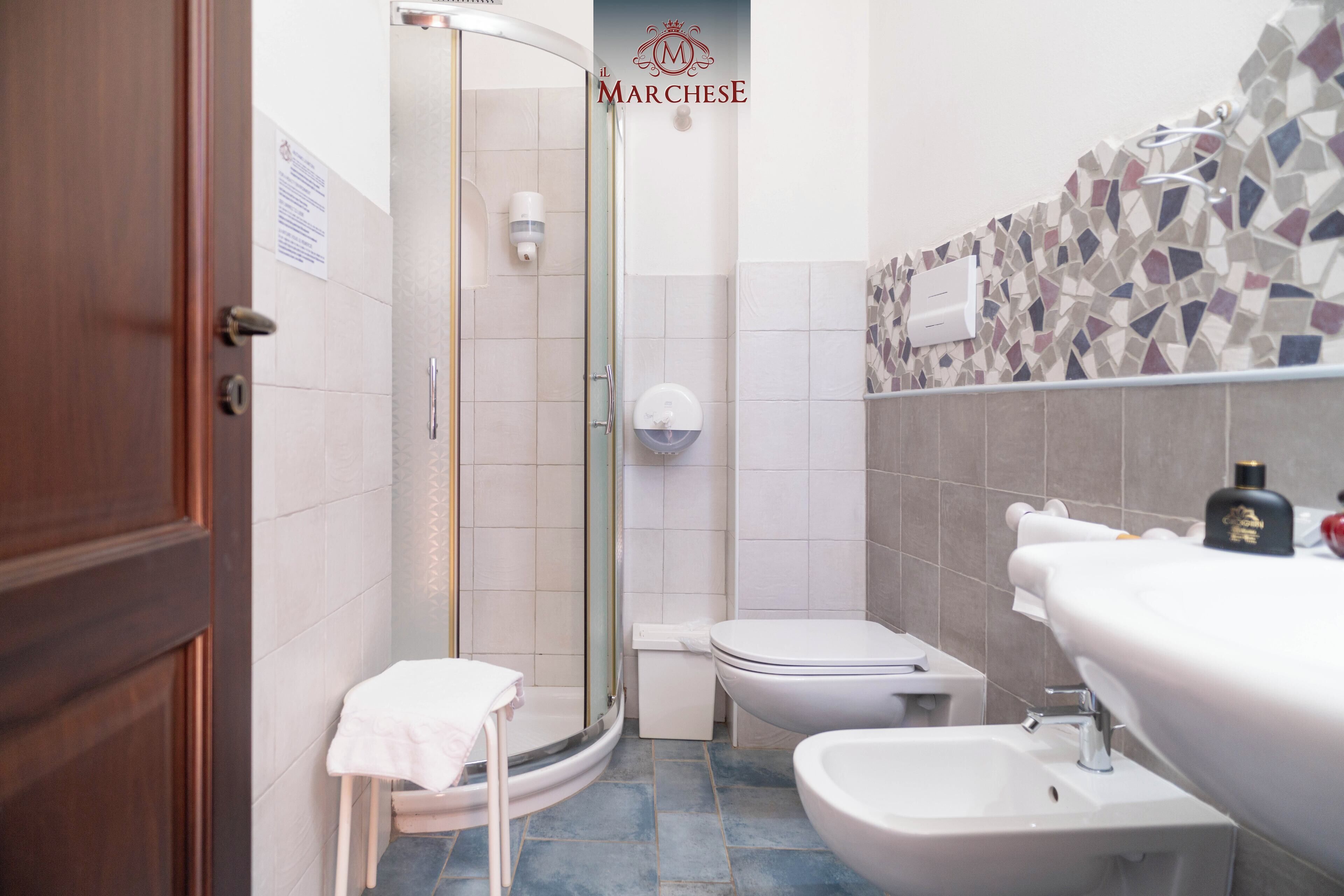 Une salle de bain avec douche, toilettes et lavabo.