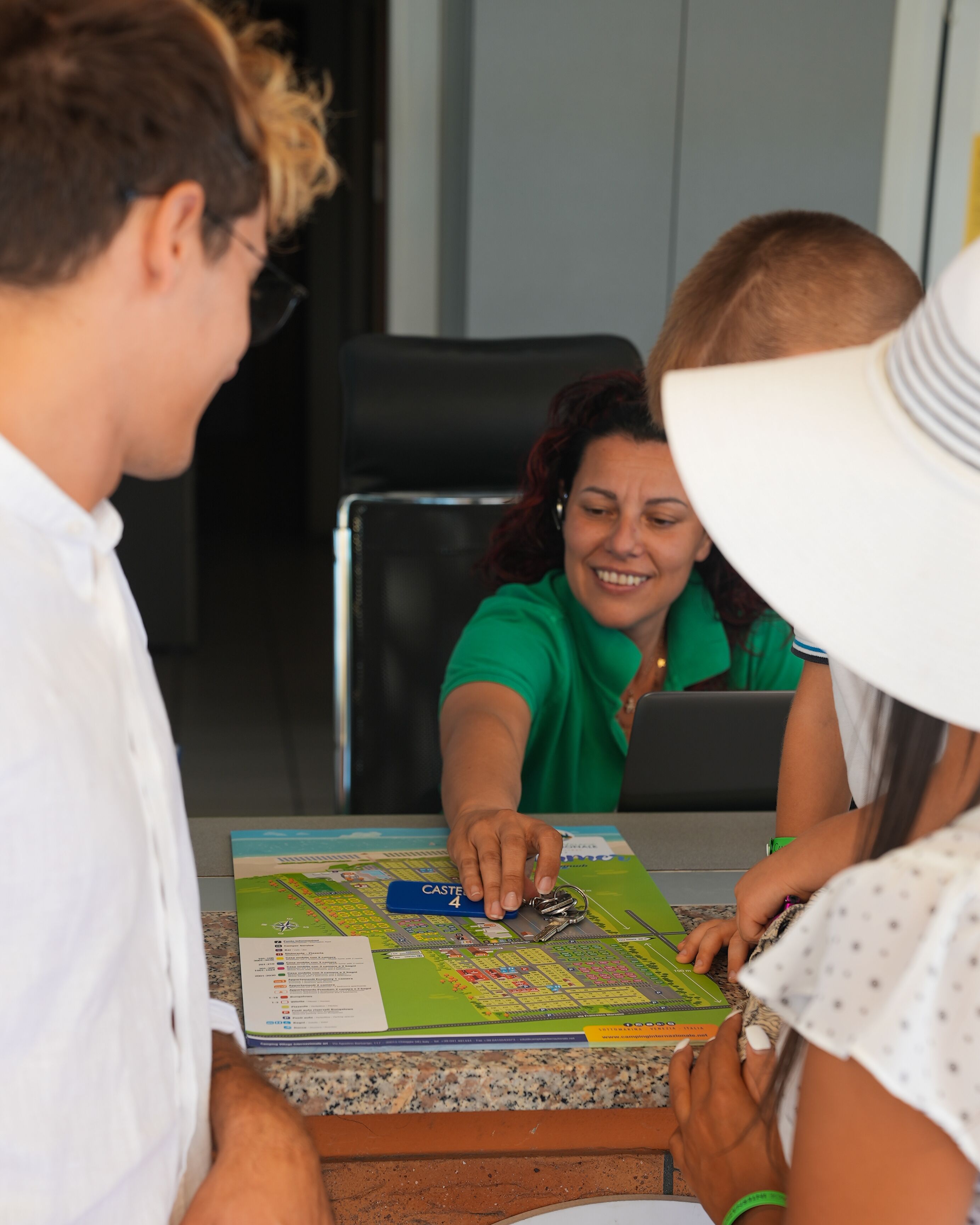 A group of people playing a board game at a table with a map and game pieces.