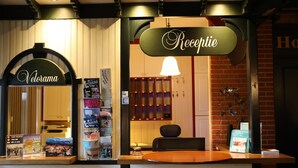 Un mostrador de recepción con un cartel que dice "Reception" y otro cartel que dice "Velorama".