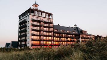 Een hotel met meerdere verdiepingen, balkons en een toren.