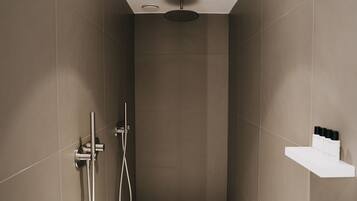 Une douche moderne dotée d’un pommeau de douche rond, d’un pommeau de douche à main et d’une étagère murale pour les articles de toilette.