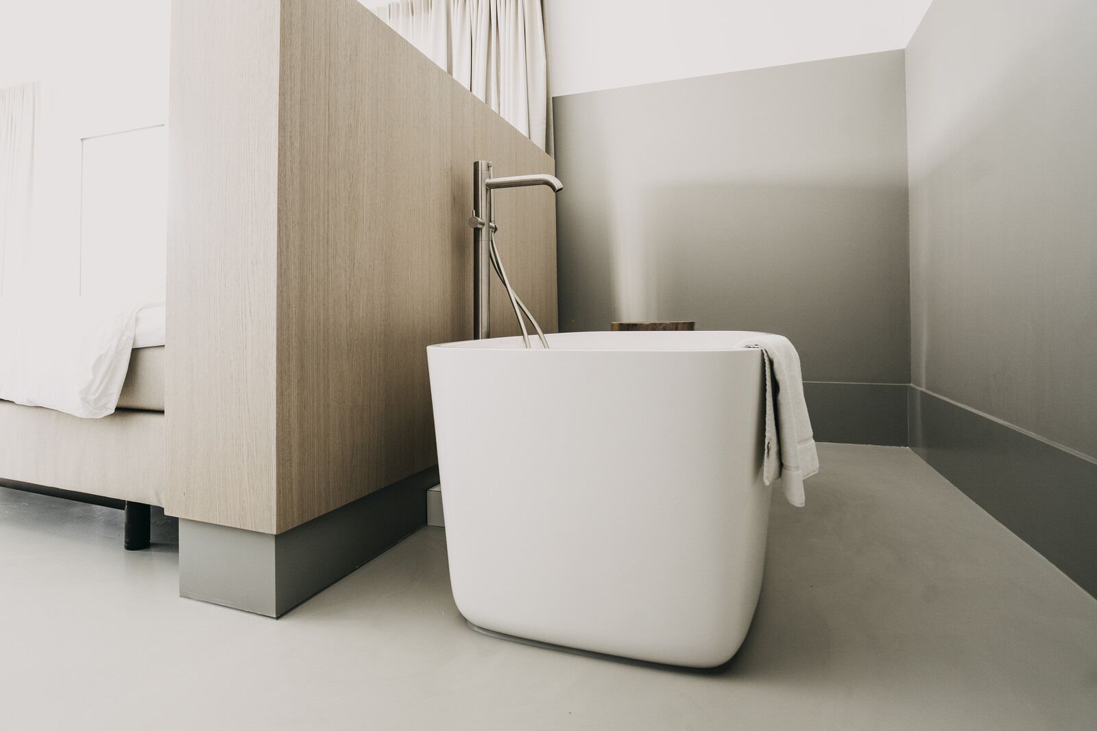 Een moderne badkamer met een minimalistisch ontwerp, voorzien van een ruime badkuip, een strakke douche en een neutrale kleurenpalet.