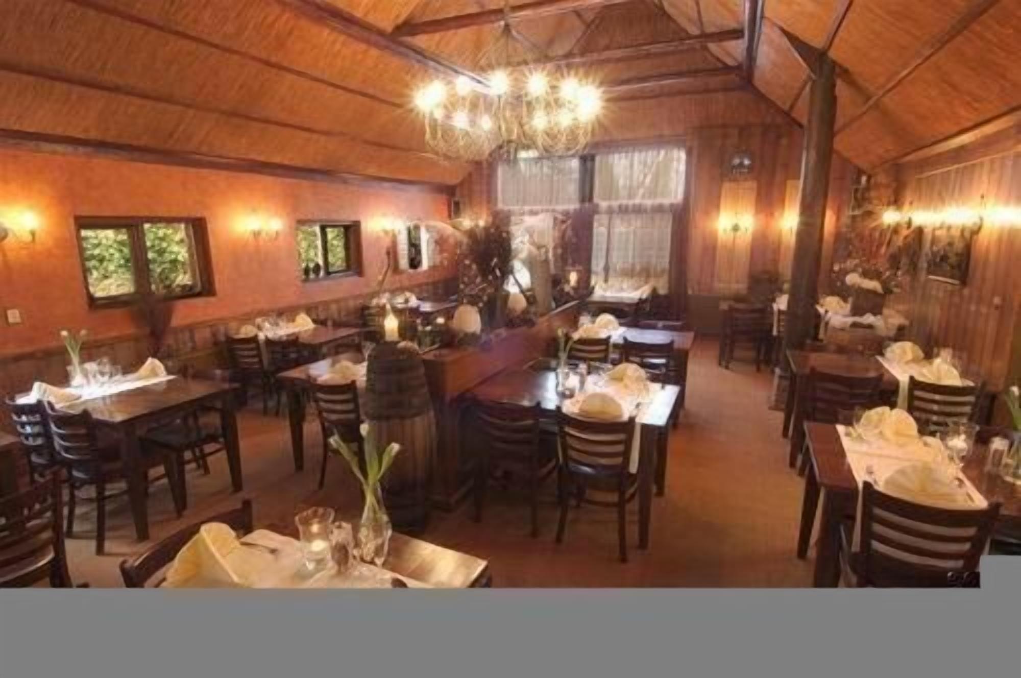 A restaurant with wooden interiors, multiple tables, and chairs.