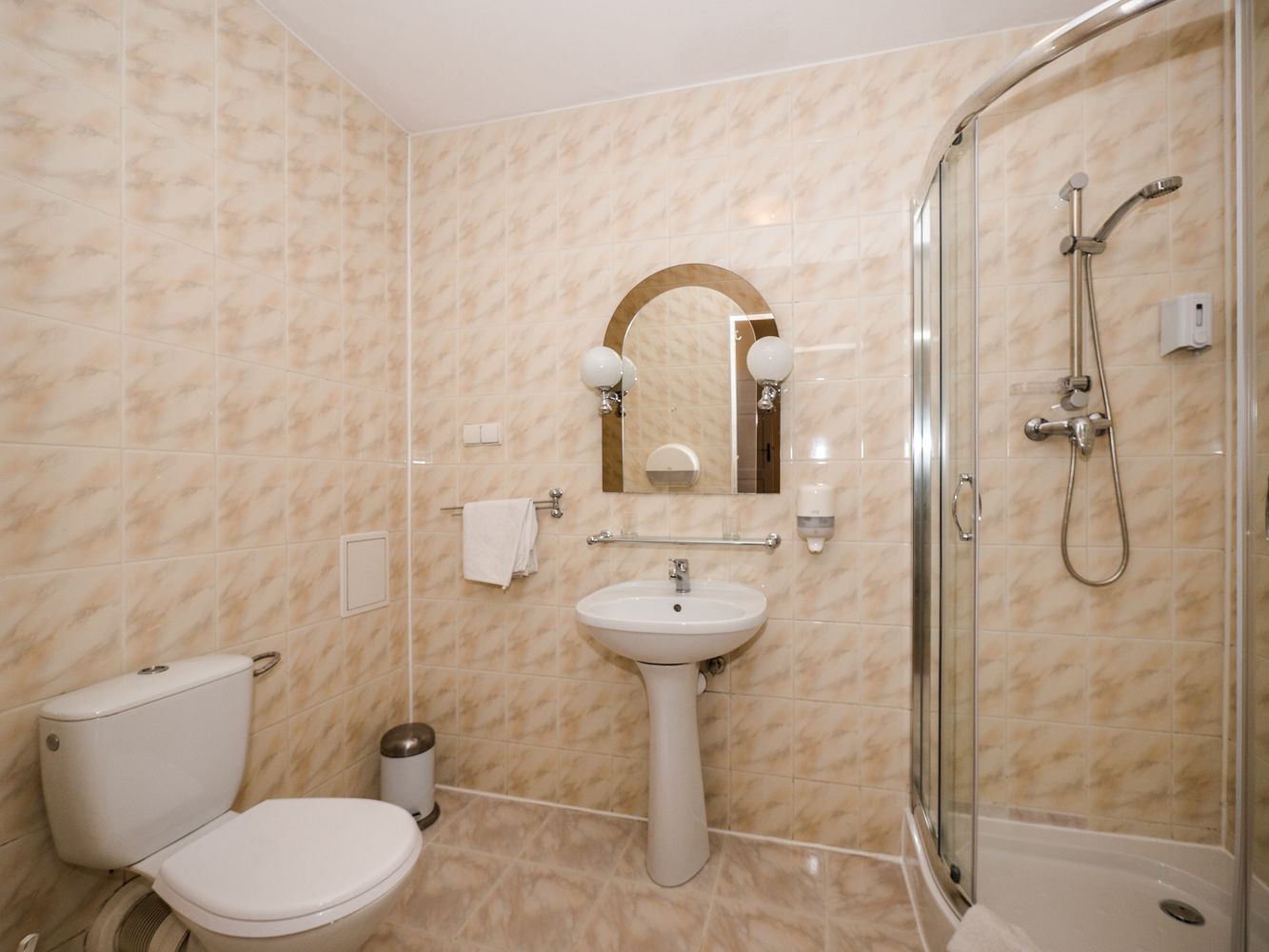 A bathroom with a toilet, sink, and shower.