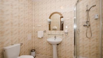 A bathroom with a toilet, sink, and shower.