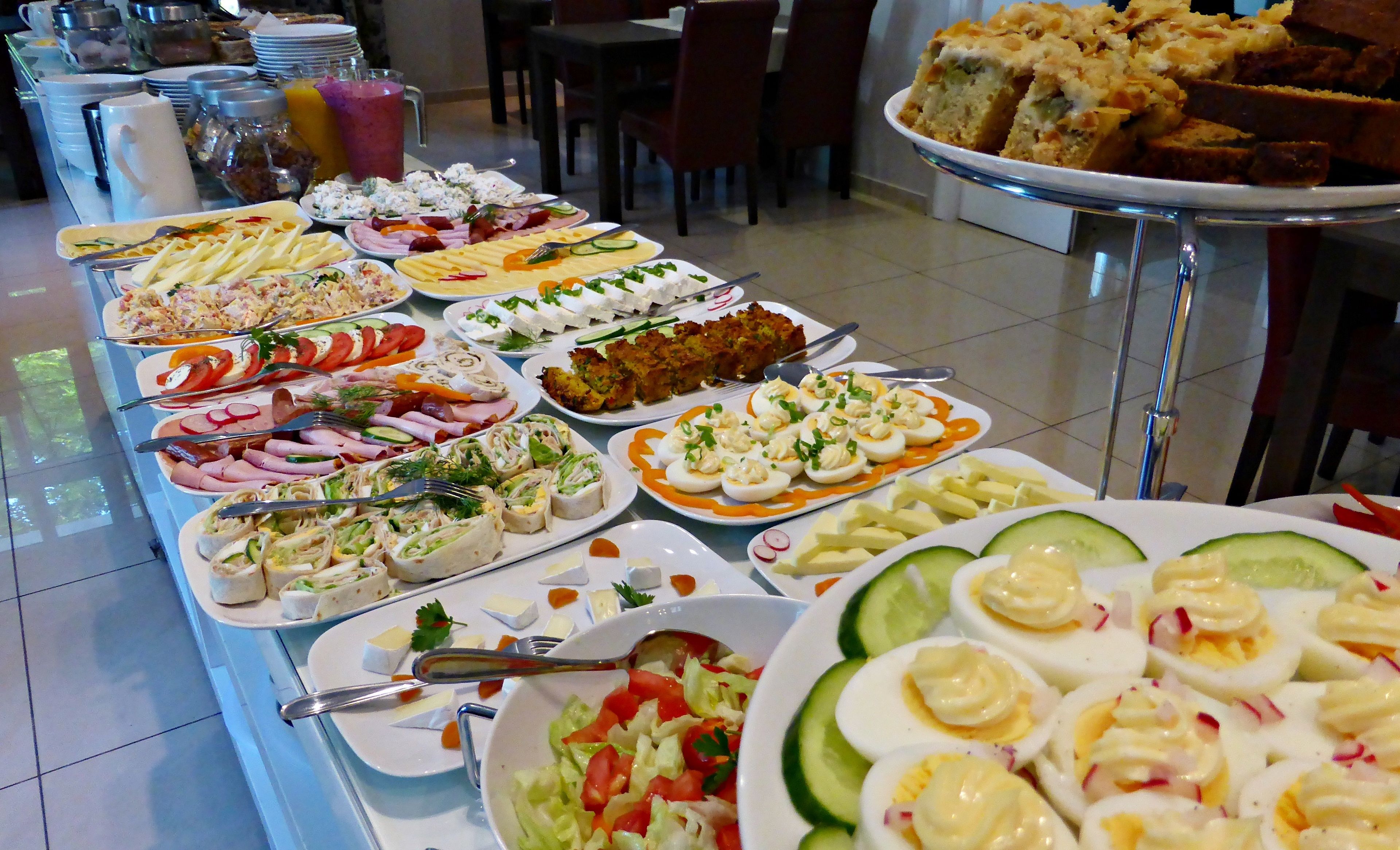 Un buffet proposant une variété de plats, notamment des salades, des viandes et des desserts.
