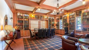 A library with bookshelves, a dining area, and leather chairs. - HarTeluk Joure (Joure)