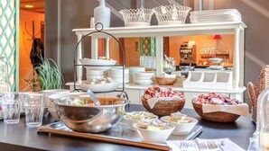 A buffet setup with various dishes, bowls, and baskets. - HarTeluk Joure (Joure)
