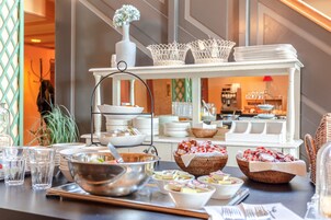 Disposição de buffet com diversos pratos, tigelas e cestos.