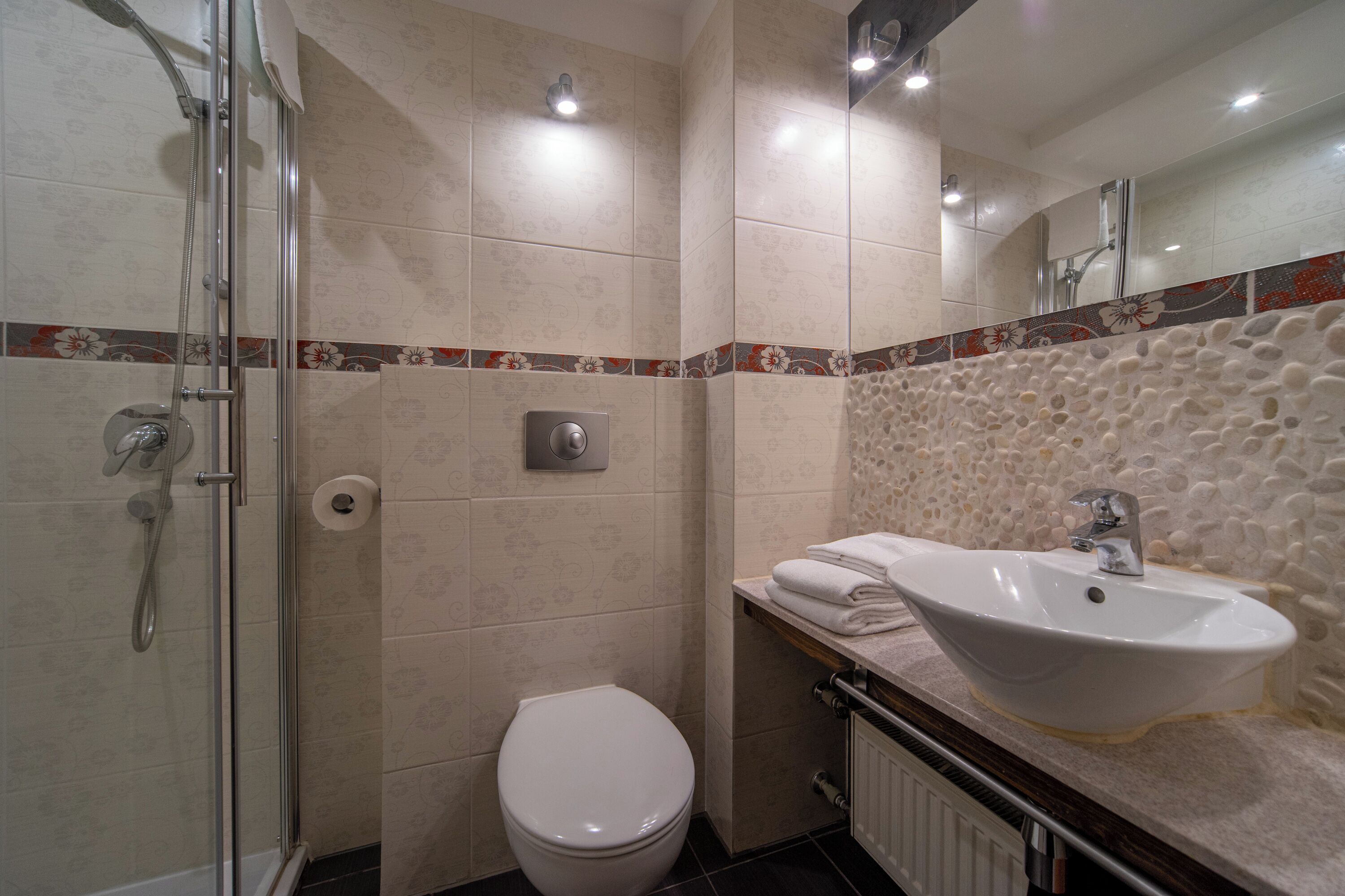 A bathroom with a shower, toilet, and sink.