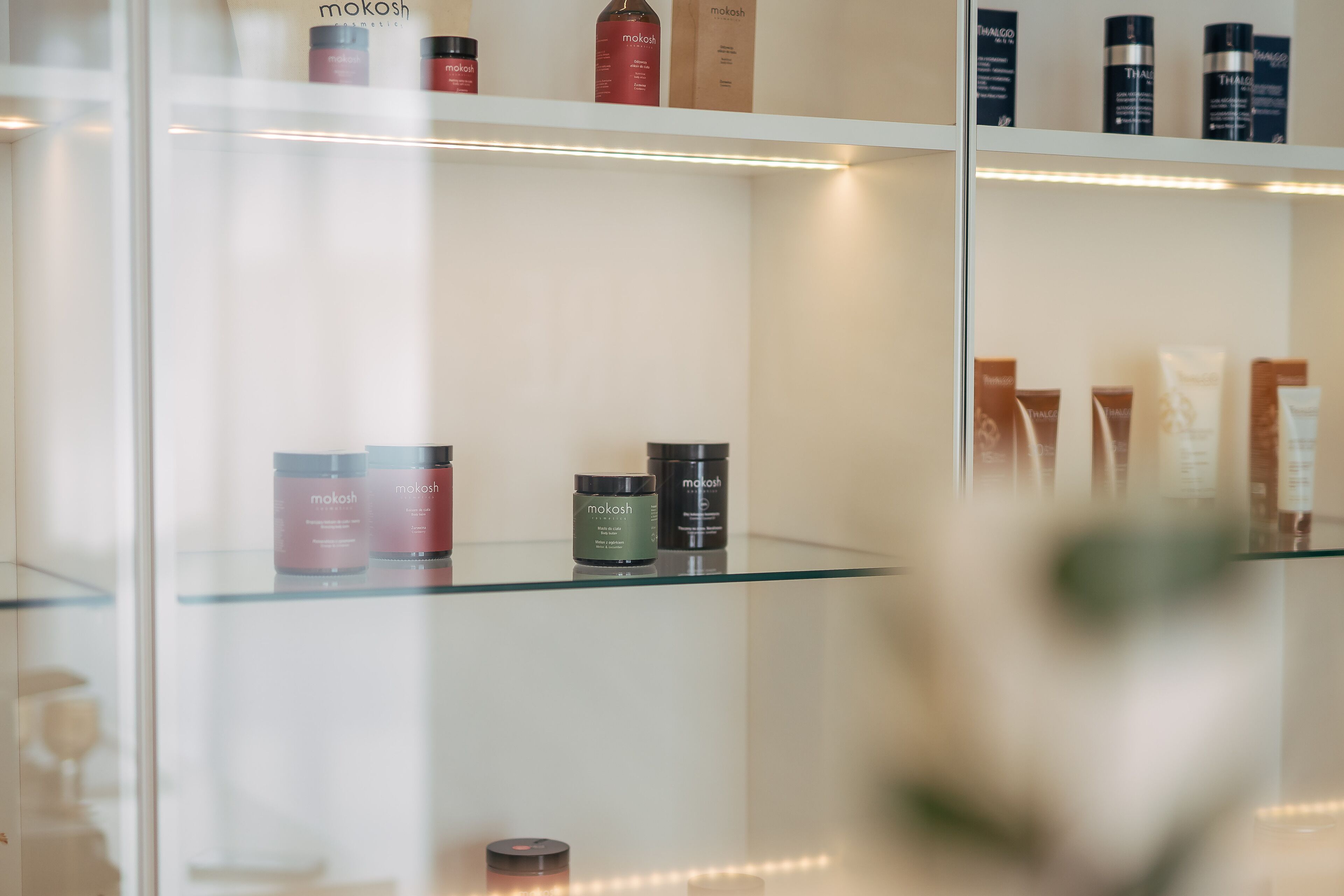 Una vitrina de cristal exhibe varios productos para el cuidado de la piel con la etiqueta 'mokosh'.