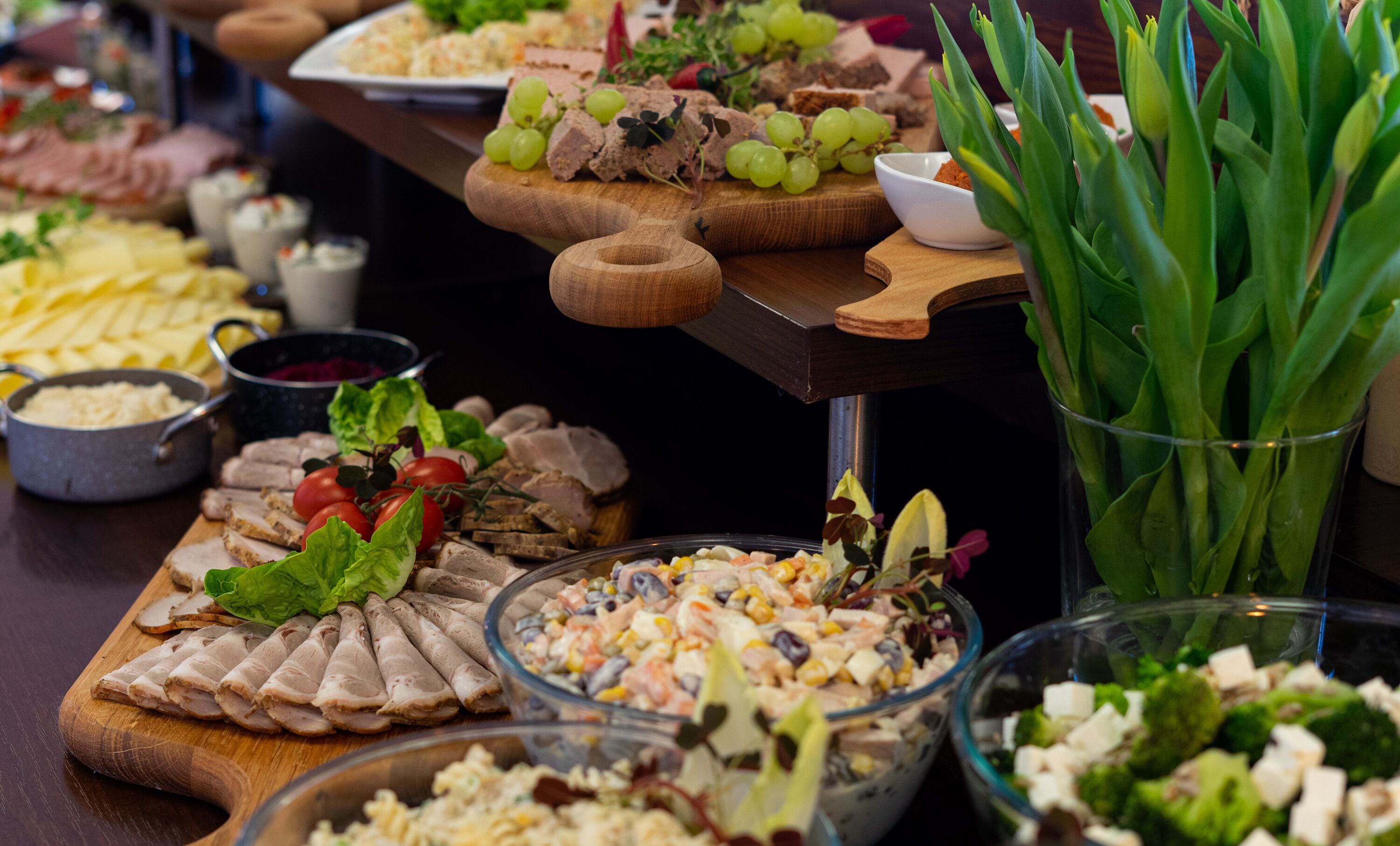 A buffet with various food items including meats, cheeses, and salads.