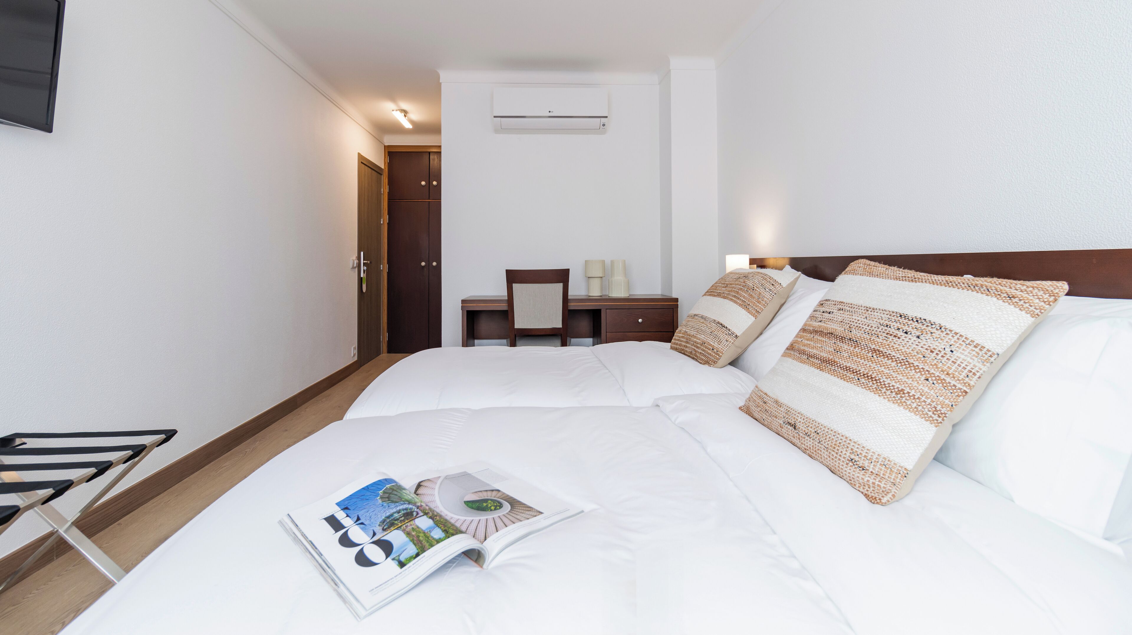 Una habitación de hotel con una cama, un escritorio y una silla.