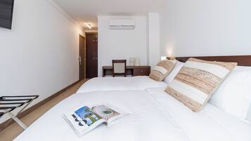 Una habitación de hotel con una cama, un escritorio y una silla.