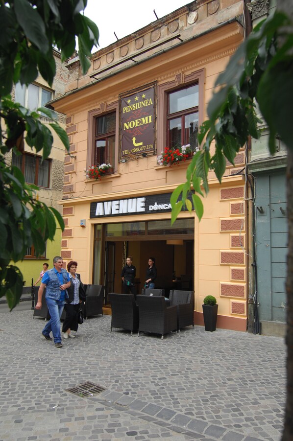 A building with a sign reading "PENSIONE NOEMI" and "AVENUE DÔNCA".