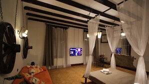 A room with a bed, a sofa, a television, and a table. - Pension Noemi (Brasov)