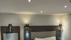 A modern hotel room with two beds, wooden headboards, bedside tables with lamps, and a neutral color scheme. - Mary's Hotel République (Paris)