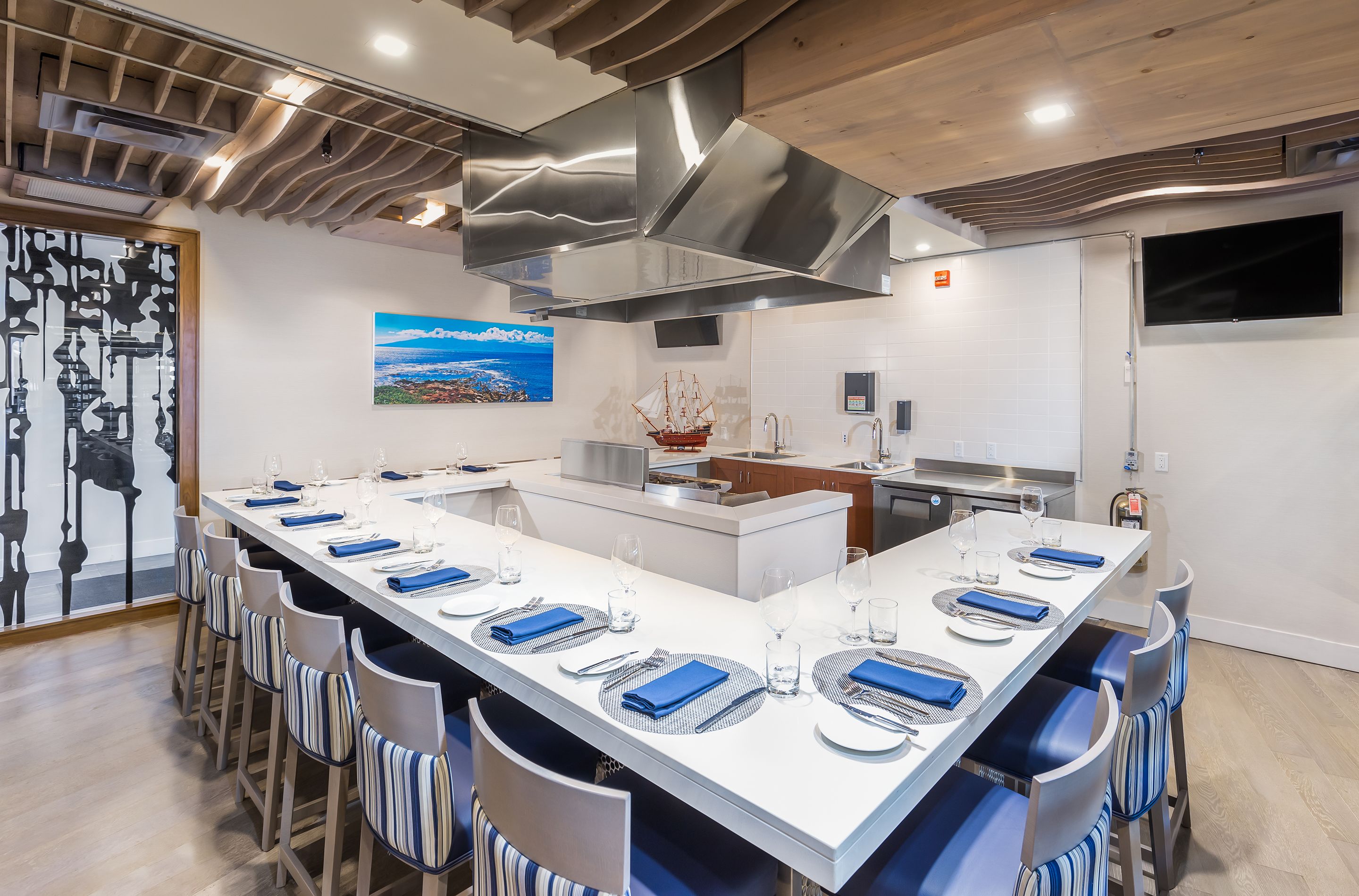 A modern kitchen with a large island, stainless steel appliances, and a view of the cityscape.