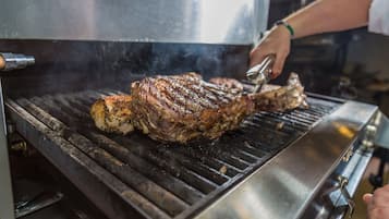 Una parrilla grande con un bistec en cocción.