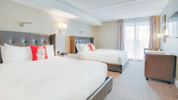 Ett hotellrum med två sängar, ett skrivbord och en stol.