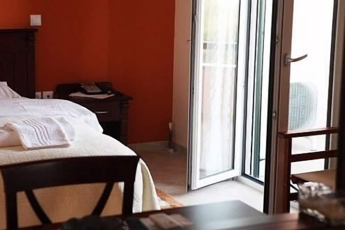A hotel room with a bed, a desk, and a chair.