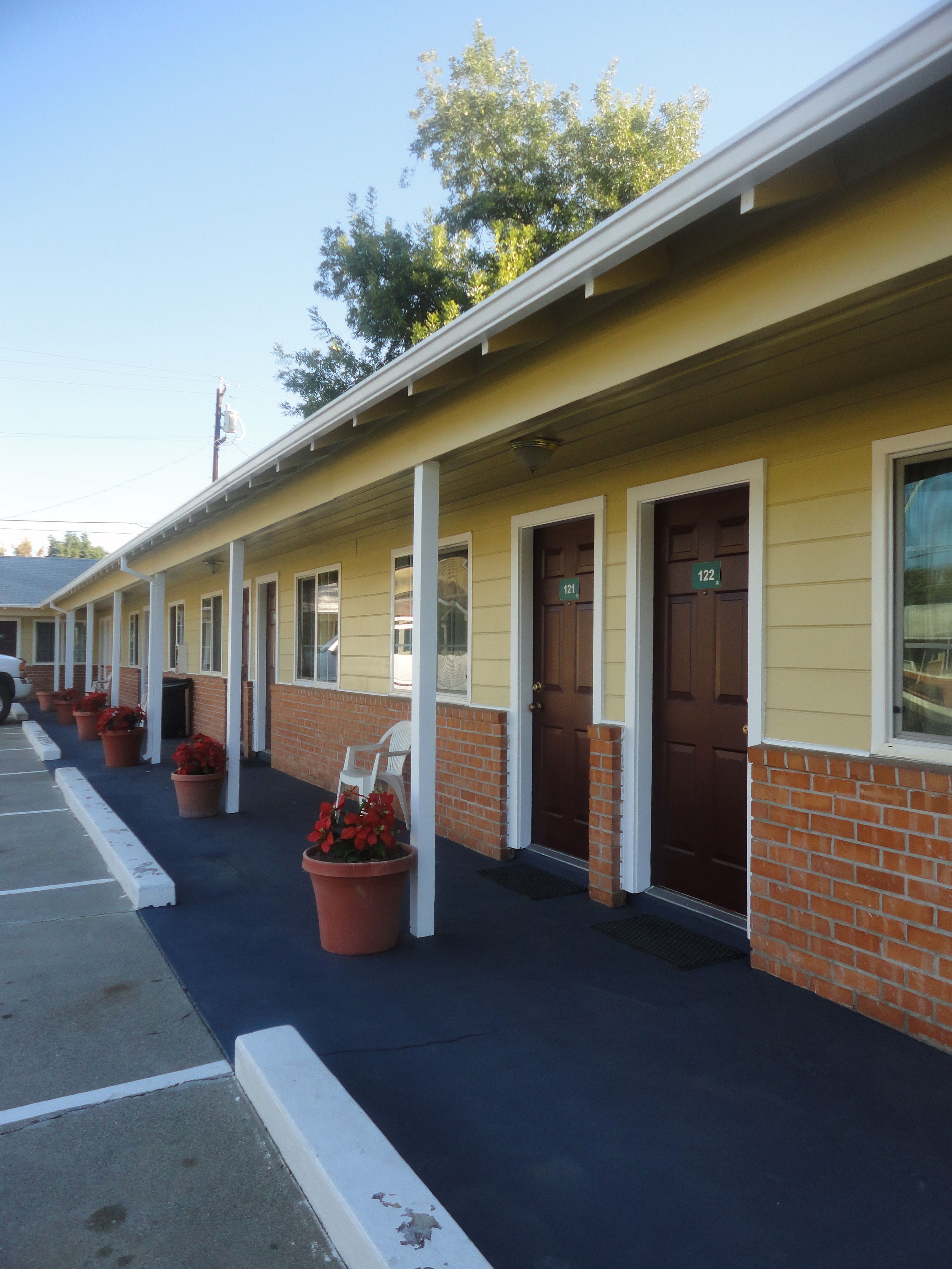 Filas de habitaciones de motel, cada una con su puerta individual y un número identificatorio.