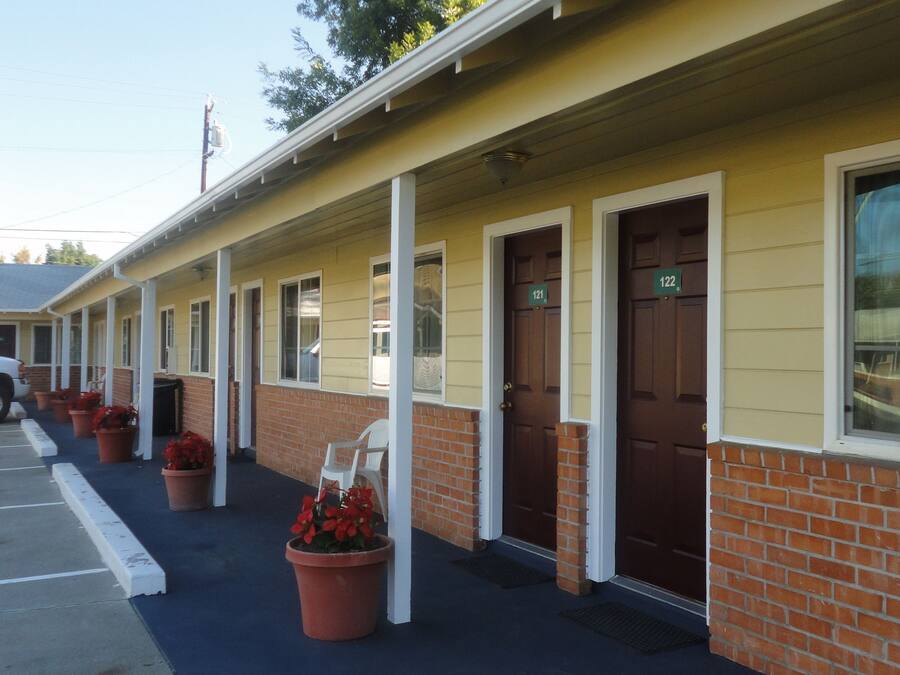 Filas de habitaciones de motel, cada una con su puerta individual y un número identificatorio.