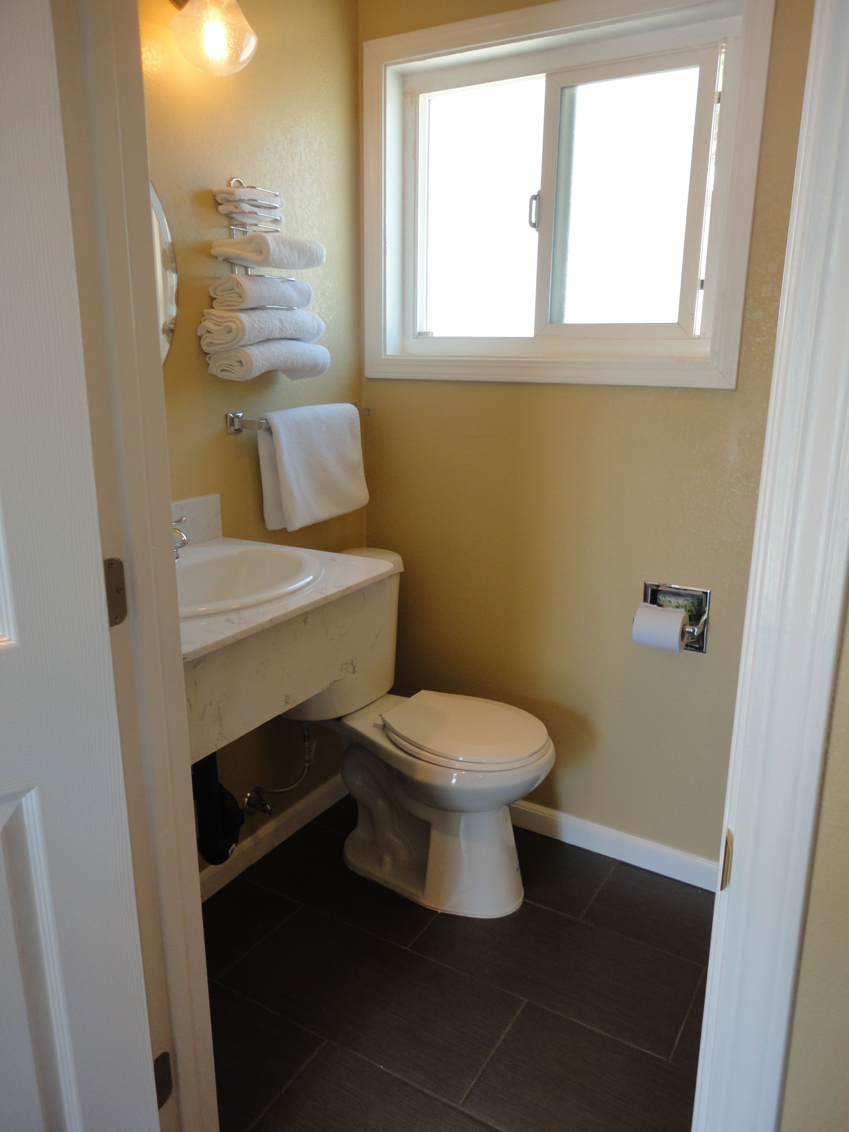Een badkamer met toilet, wastafel en handdoekhouder.